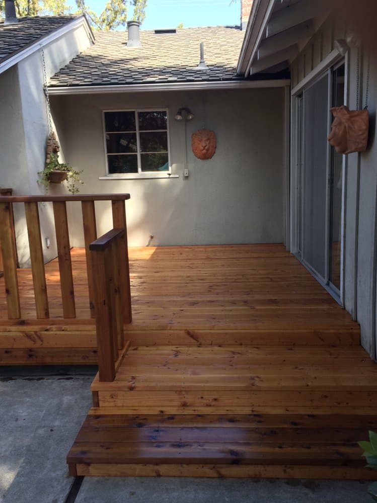 Freshly finished redwood deck and steps wrapping a Peninsula home